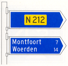 Verkeersbord K6: Beslissingswegwijzer langs niet-autosnelweg met interlokale doelen en routenummer niet-autosnelweg