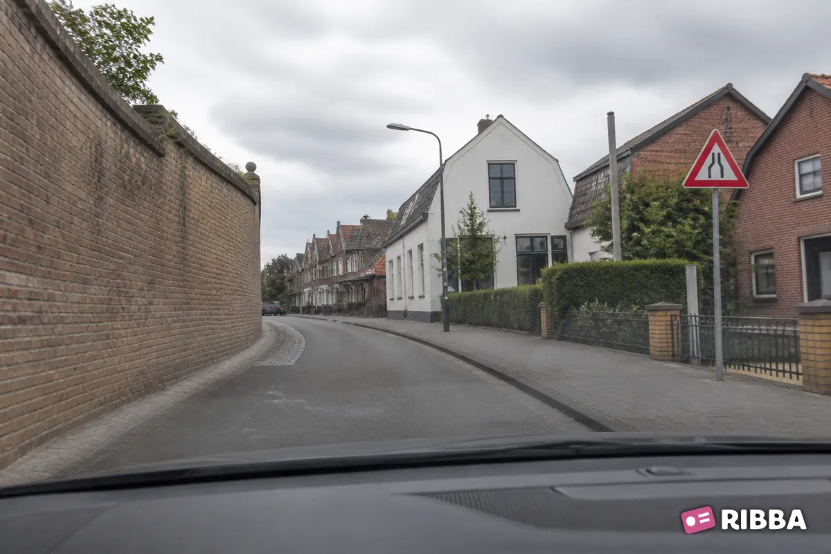 Bord J19 Rijbaanversmalling links langs een Nederlandse weg