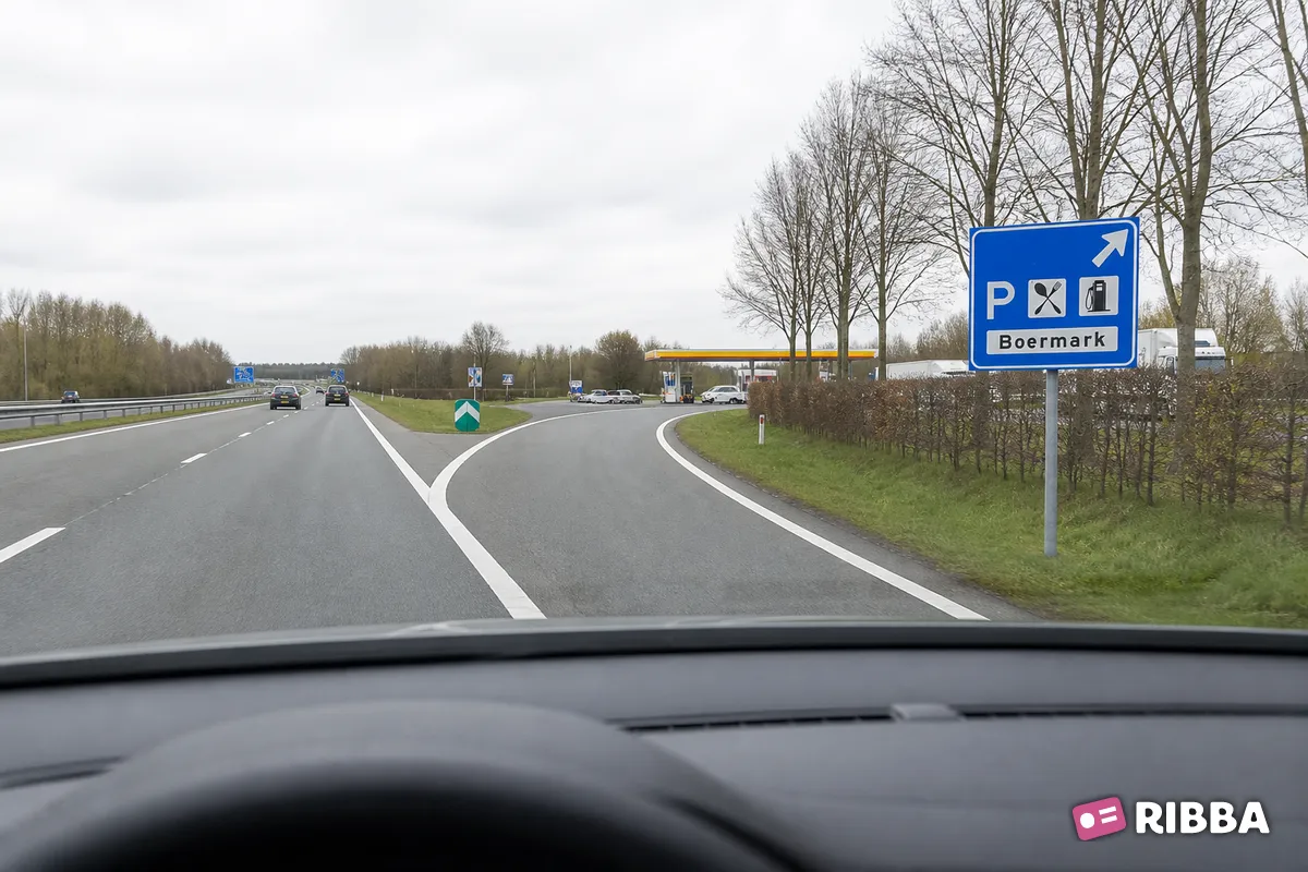 Bord K3 Beslissingswegwijzer langs autosnelweg voor de afgaande richting naar een verzorgingsplaats, met de naam van de parkeerplaats en symbolen die de aard van de voorzieningen aangeven langs een Nederlandse weg