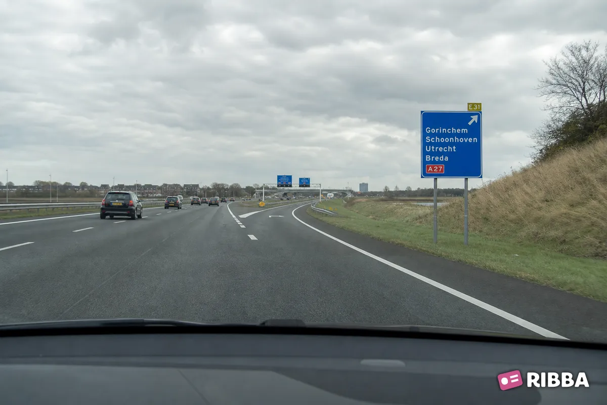 Bord K4 Hoge beslissingswegwijzer langs autosnelweg met rijstrookpaneel voor de doorgaande richting en aftakkingspaneel voor de afgaande richting, met interlokale doelen, routenummers autosnelwegen en Europes langs een Nederlandse weg