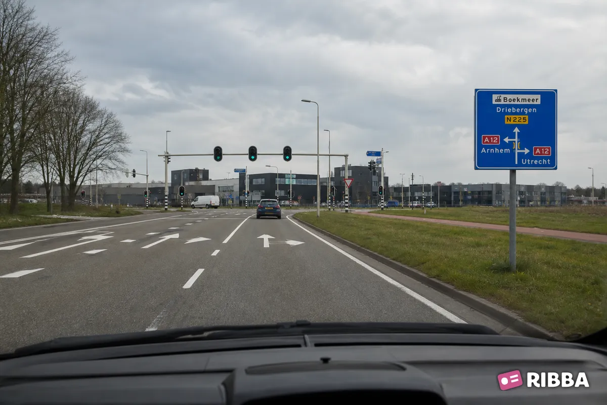 Bord K5 Voorwegwijzer langs niet-autosnelweg, met interlokale doelen, routenummers, viaductsymbool en aanduiding industrieterrein langs een Nederlandse weg