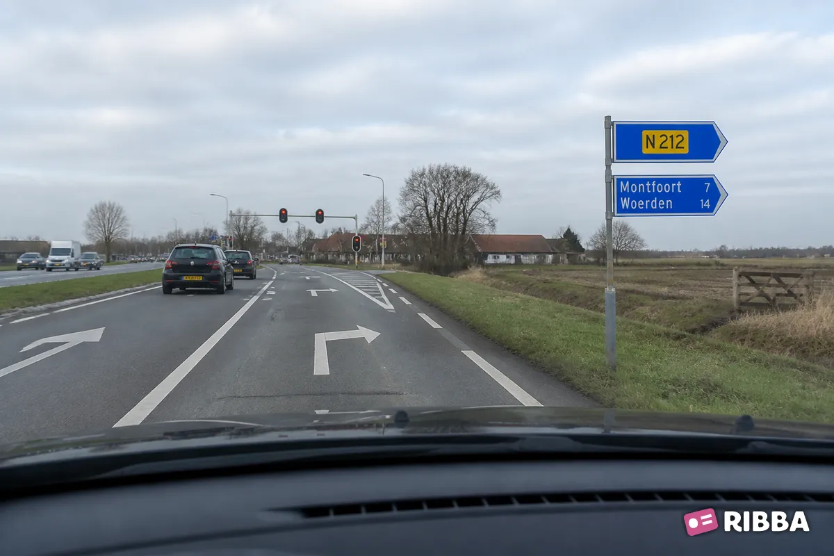 Bord K6 Beslissingswegwijzer langs niet-autosnelweg met interlokale doelen en routenummer niet-autosnelweg langs een Nederlandse weg