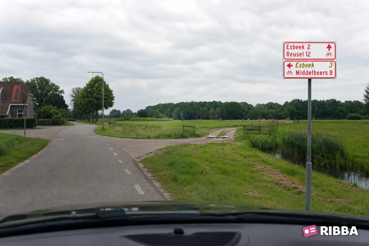 Bord K8 Wegwijzer voor fietsers en bromfietsers (stapelbord), met interlokale doelen en een via een alternatieve route te bereiken doel (cursief) langs een Nederlandse weg